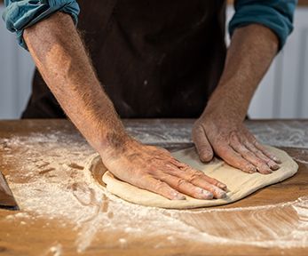 Stendere la pizza con le mani Stendere la pizza con le mani