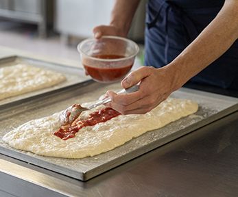 Stendere la pizza nella teglia Stendere la pizza nella teglia
