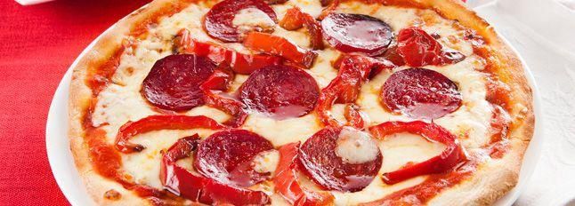 Pizza rossa con peperoni, salame e tabasco