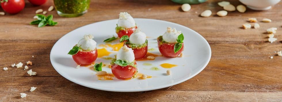 Pomodorini ripieni di mozzarelline, pesto alle mandorle e pane croccante