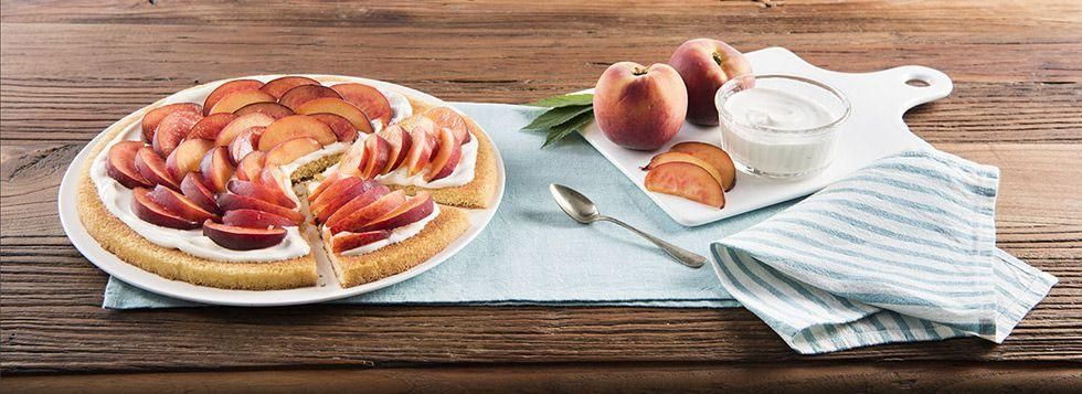Fruit Pizza di pan di spagna con crema alla ricotta e pesche
