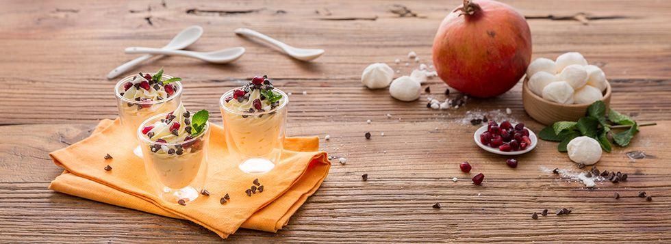 Bicchierino di crema dolce al mascarpone con gocce di cioccolato e melograno