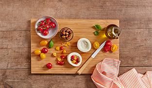 tagliate i pomodorini gialli e rossi e unite le olive taggiasche