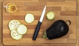 Sbucciate e tagliate a fette le melanzane. Sbucciate e tagliate a fette le melanzane.