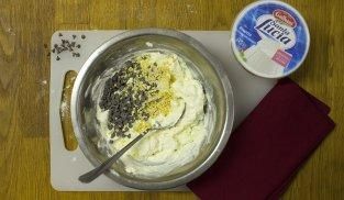 lavorare in una ciotola la ricotta con la panna, gocce di cioccolato e granella di mandorle lavorare in una ciotola la ricotta con la panna, gocce di cioccolato e granella di mandorle