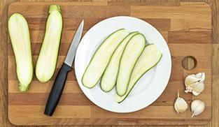Pulite e lavate le zucchine, tagliatele per il senso della lunghezza Pulite e lavate le zucchine, tagliatele per il senso della lunghezza