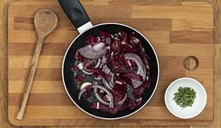 Pulite e tagliate a fettine sottili la cipolla e il radicchio. Fate appassire accompagnando il tutto con uno spicchio d'aglio Pulite e tagliate a fettine sottili la cipolla e il radicchio. Fate appassire accompagnando il tutto con uno spicchio d'aglio