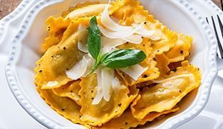 guarnire i ravioli di zucca e ricotta con del basilico guarnire i ravioli di zucca e ricotta con del basilico
