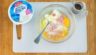 lavorare in una ciotola le uova con la ricotta e il prosciutto cotto lavorare in una ciotola le uova con la ricotta e il prosciutto cotto